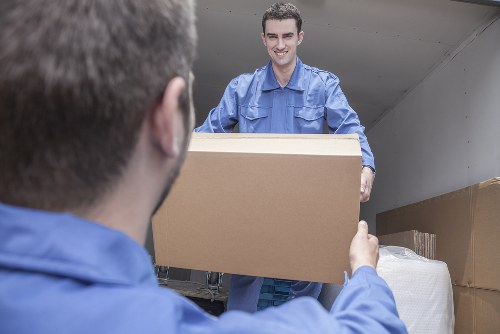 Professional movers handling furniture in a Stockwell street
