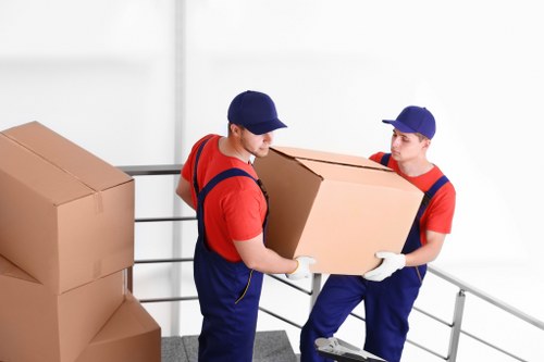 Movers carrying household items down stairs in a Stockwell flat